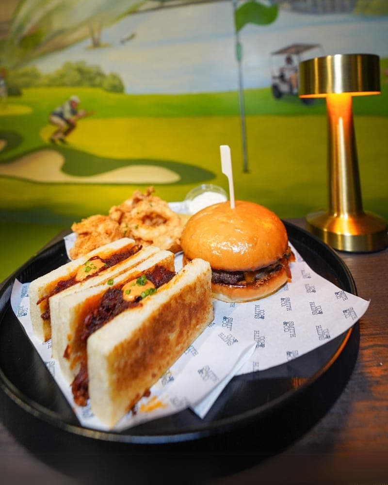 Smith & Co smash burger, katsu sandwich, and calamari served at LENGOLF Bangkok